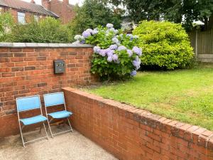 duas cadeiras sentadas ao lado de uma parede de tijolos em Headrose House em West Bromwich