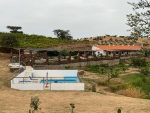 una piscina en medio de un campo en Herdade da Moringa, en Corte do Pinto