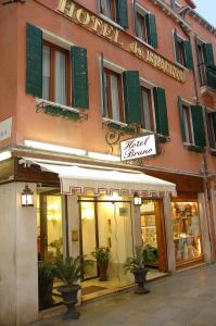 una tienda frente a un edificio con un cartel. en Hotel Da Bruno, en Venecia