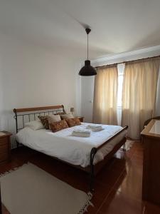 ein Schlafzimmer mit einem großen Bett mit weißer Bettwäsche in der Unterkunft Azenhas Apartment in Sintra