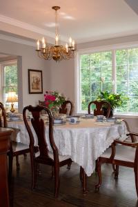 a dining room with a table with chairs and a chandelier at Upper Canada Coach House in Niagara on the Lake