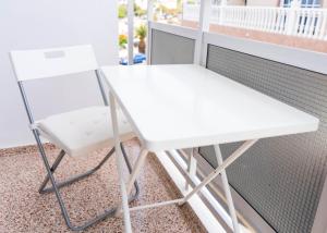 een wit bureau en een stoel op een balkon bij Pensión Alcalá in Alcalá