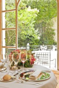 a table with glasses and plates of food and a window at Relais & Châteaux Hotel Orfila in Madrid