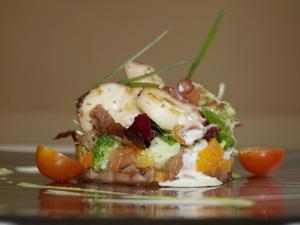 a plate of food with vegetables and oranges on a table at Relais & Châteaux Hotel Orfila in Madrid