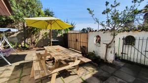 a wooden picnic table with an umbrella on a patio at La Casa del Tata, El Quisco in El Quisco