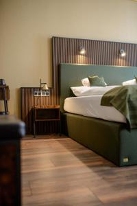 a bedroom with a large bed and a night stand at Stadthotel König Albert in Zittau