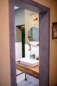 La salle de bains est pourvue d'un lavabo et d'un miroir. dans l'établissement Stadthotel König Albert, à Zittau