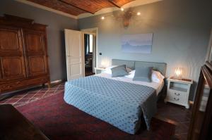 Schlafzimmer mit einem Bett mit blauer Decke in der Unterkunft Villa Crissante in La Morra