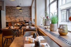a restaurant with wooden tables and chairs and windows at Stadthotel König Albert in Zittau