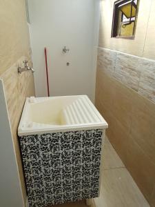 ein Bad mit einem schwarzen und weißen Waschbecken und einer Dusche in der Unterkunft Casa Toá, Chapad dos Veadeiros in Alto Paraíso de Goiás