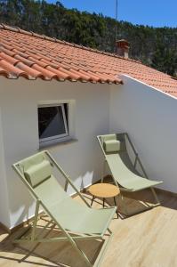 two chairs and a table on a patio at Vita Portucale ! Paragem dos Pacatos - Odeceixe in Odeceixe