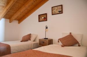 two beds in a room with wooden ceilings at Paragem dos Pacatos - Odeceixe in Odeceixe