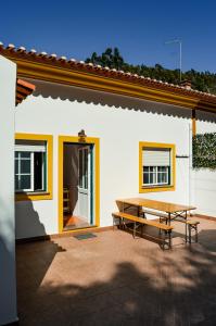eine Terrasse mit einem Picknicktisch neben einem Haus in der Unterkunft Vita Portucale ! Paragem dos Pacatos - Odeceixe in Odeceixe