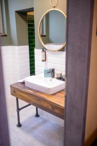 La salle de bains est pourvue d'un lavabo blanc et d'un miroir. dans l'établissement Stadthotel König Albert, à Zittau