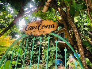 un panneau indiquant un restaurant de cacoco sous un arbre dans l'établissement Casa Cereza Apartments, à Puerto Vallarta