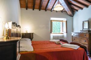 a bedroom with a red bed with a dresser and a window at Podere San Piero detto "Villa di Grace" in Vaglia