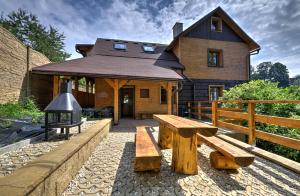 a wooden house with a bench in front of it at Penzion Pulčiny 43 in Pulčín