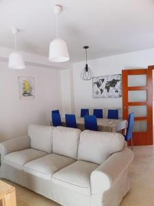 een woonkamer met een witte bank en een tafel bij Chalet amplio con Jardín y zona barbacoa. in Reus