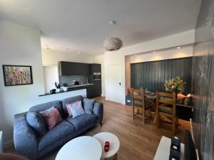 ein Wohnzimmer und eine Küche mit einem Sofa und einem Tisch in der Unterkunft Nisterlo Guesthouse in Nistelrode