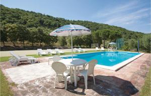 a table with an umbrella next to a swimming pool at Casa Cantina in Magione