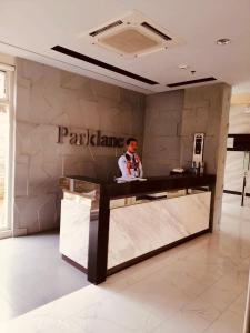 a man standing at a reception desk in a lobby at The Rochester Parklane Condominium in Manila
