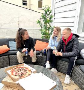 a group of people sitting on a couch with a pizza at Fabryka in Bergen