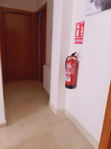 a fire extinguisher hanging on a wall next to a door at Chalet amplio con Jardín y zona barbacoa. in Reus