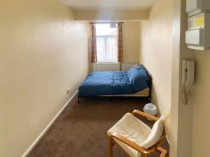 a small room with a bed and a chair at Headrose House in West Bromwich
