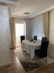 a dining room with a white table and chairs at Anja Apartman in Bosanski Šamac