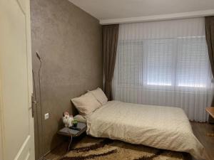a small bedroom with a bed and a window at Anja Apartman in Bosanski Šamac
