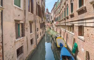 a canal between two buildings with a boat in it at Nice apartment in Venezia with 2 Bedrooms and WiFi in Venice
