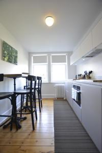 - une cuisine avec des placards blancs, une table et des chaises dans l'établissement Appartement Chic, à Bruxelles