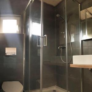 a bathroom with a shower with a glass door at BALTICO Domki Letniskowe in Sarbinowo +48 photos