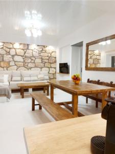 una sala de estar con mesas de madera y una pared de piedra. en Villa DORIANA IN PELEKOUDA en Pollonia