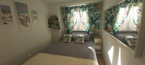 a small bedroom with a bed with two pillows on it at Seixal Bay House!! in Seixal