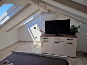a living room with a flat screen tv in a attic at CASTEL in Mali Lošinj