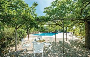 een tafel en stoelen voor het zwembad bij Stunning Home In Trequanda Si With 2 Bedrooms, Wifi And Outdoor Swimming Pool in Trequanda