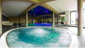 a large tub in a room with a swimming pool at Apartmány a Chalety Horizont Resort in Stará Lesná
