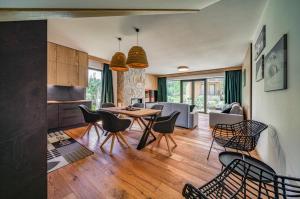 a kitchen and living room with a table and chairs at Apartmány a Chalety Horizont Resort in Stará Lesná