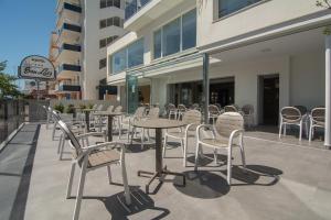 una fila de mesas y sillas en un patio en Hotel San Luis, en Gandía