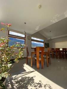 uma sala de jantar com mesas e cadeiras de madeira e janelas em Casa Tramontana em Mérida