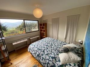 a bedroom with a bed and a large window at Cabaña Girasol - Cocina Parking Piscina Wifi in Algarrobito