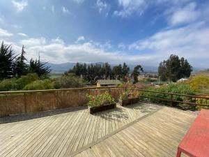 a wooden deck with two potted plants on it at Cabaña Girasol - Cocina Parking Piscina Wifi in Algarrobito +18 photos