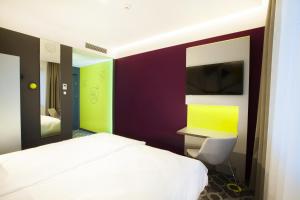 a bedroom with a white bed and a tv at Hotel Alto Żory in Żory