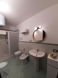 ein Badezimmer mit einem Waschbecken, einem WC und einem Spiegel in der Unterkunft I Vicini del Re Holiday Home in Palermo