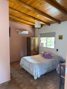 - une chambre avec un lit et un plafond en bois dans l'établissement Los Horneros, Cabañas, à San Marcos Sierras