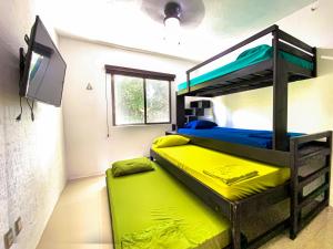 una camera con 2 letti a castello e una TV a schermo piatto di Villa Selvática con Piscina Privada en Playa del Carmen a Playa del Carmen
