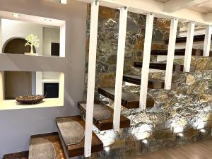 een lobby met een stenen muur en een trap bij Stylish loft with fireplace, jacuzzi and gym in Agios Nikolaos