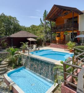 a swimming pool in front of a house at Villa Bayacanes con piscinas privadas in Jarabacoa