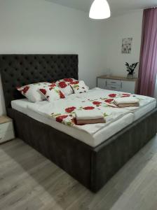 a bedroom with a large bed with red flowers on it at Apartmán Dolinky in Vyhne